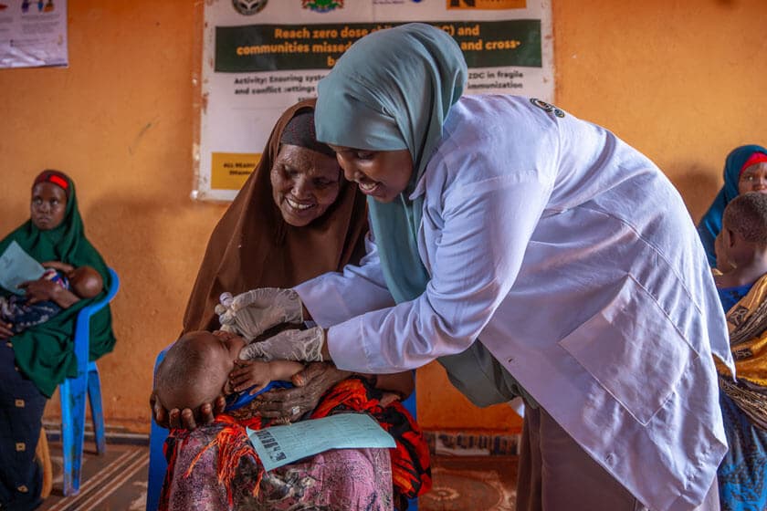 Nurse administers an oral vaccine to a child, held by his grandmother in Southwest State, Somalia. Credit: Mohamed Abdihakim Ali