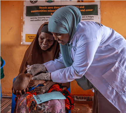 Nurse administers an oral vaccine to a child, held by his grandmother in Southwest State, Somalia. Credit: Mohamed Abdihakim Ali